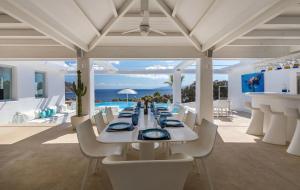 a dining room with a table and a view of the ocean at Fortan 5* villa in Mýkonos City