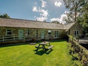 a stone house with a picnic table in the yard at 2 Bed in Sanquhar 89402 in Sanquhar