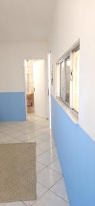 an empty room with a blue wall and a hallway at Afrolar - Vizinhas de Iemanjá in Salvador