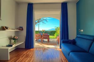 ein Wohnzimmer mit einem blauen Sofa und einem Tisch in der Unterkunft Casa con 2 camere da letto,piscina jacuzzi AC wifi e bici elettriche in Bordighera