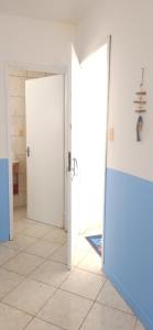 um quarto com duas portas brancas e um piso de azulejo em Afrolar - Vizinhas de Iemanjá em Salvador