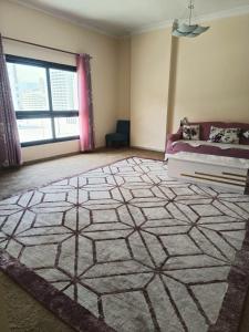 een woonkamer met een groot tapijt op de vloer bij 1 BHK fully furnished apartment in Dubai