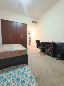 uma sala com um quarto com uma secretária e uma cama em 1 BHK fully furnished apartment em Dubai