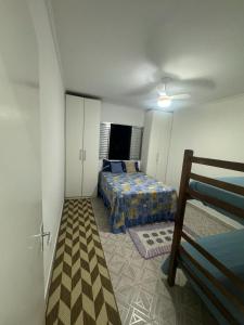 a bedroom with a bed in a room with a bed sqor at Apartamento em Praia Grande in Praia Grande