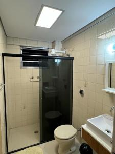 a bathroom with a shower with a toilet and a sink at Apartamento em Praia Grande in Praia Grande