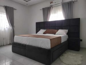 a bedroom with a large bed with a large headboard at Dapi Home Residence in Lomé