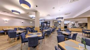 a restaurant with wooden tables and blue chairs at Blue Mountain Resort in Szklarska Poręba