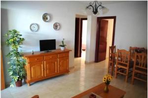 salon z telewizorem na drewnianej szafce w obiekcie Apartamentos los Boliches w mieście Puerto de Mazarrón
