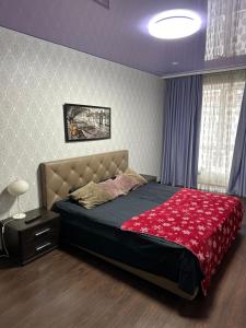 ein Schlafzimmer mit einem großen Bett mit einer roten Decke in der Unterkunft Sweet Home in Dnipro