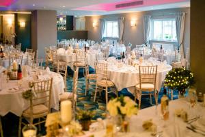 a room full of tables and chairs with white table cloth at The Holt Hotel in Steeple Aston
