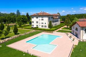 an aerial view of a large house with a large swimming pool at Villa Raggi Relais in Castelletto d'Orba