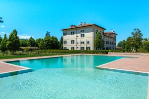 uma grande piscina em frente a um edifício em Villa Raggi em Castelletto d'Orba