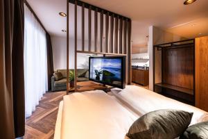 1 dormitorio con 1 cama y TV de pantalla plana en Zeit und Raum Hotel - Self Check-In, en Eggelsberg
