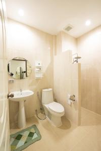 une salle de bain avec toilettes, lavabo et miroir dans l'établissement Maryo Resort Chiangrai - SHA Plus, à Chiang Rai