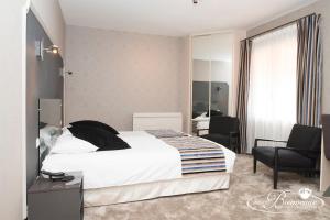 une chambre d'hôtel avec un lit et deux chaises dans l'établissement Logis Auberge Bienvenue, à Doué-la-Fontaine