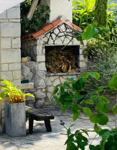 a stone fireplace with a bench in front of it at Great 4-bedroom villa w heated eco pool in Duće