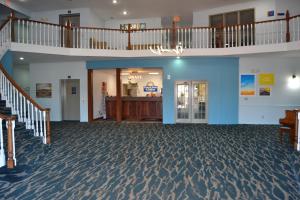 a large room with a staircase and a lobby at Days Inn and Suites by Wyndham Sikeston in Sikeston