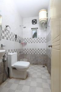 ein Bad mit einem WC und einem Waschbecken in der Unterkunft Naksha Tree Hotels, Honey Crest- Ramapuram in Chennai