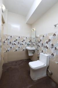 een badkamer met een toilet en een wastafel bij Naksha Tree Hotels, Honey Crest- Ramapuram in Chennai