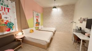 Kleines Zimmer mit 2 Betten und einem Schreibtisch. in der Unterkunft 逢甲菓子宿 in Taichung