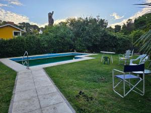 um quintal com piscina, mesa e cadeiras em Chalet Araceli em Pinamar