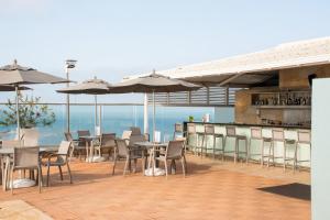 um restaurante com mesas, cadeiras e guarda-sóis em Hotel Capilla del Mar em Cartagena de Indias