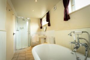 a bathroom with a bath tub and a shower at The Collyweston Slater in Collyweston