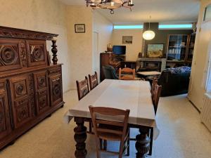 uma sala de jantar com uma grande mesa de madeira e cadeiras em Jolie Maison 3 chb- 7 lits- jardin em Levroux