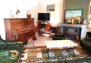 uma sala de estar com um piano e uma mesa em Jolie Maison 3 chb- 7 lits- jardin em Levroux