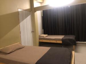 1 Schlafzimmer mit 2 Betten und einem Fenster mit Vorhängen in der Unterkunft THE Pi HOMESTAY IMPHAL MANIPUR in Imphal