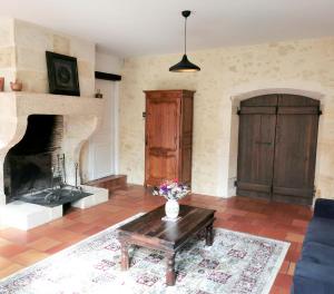 sala de estar con chimenea y mesa de centro en Les Jardins de Camelot, en Villegouge