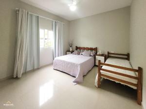 - une chambre avec 2 lits et une fenêtre dans l'établissement NossoApê Recanto: Casa de 3 quartos em Lima Duarte, à Lima Duarte