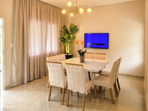 - une salle à manger avec une table, des chaises et une télévision dans l'établissement NossoApê Recanto: Casa de 3 quartos em Lima Duarte, à Lima Duarte