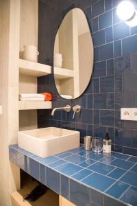 ein blau gefliestes Bad mit einem Waschbecken und einem Spiegel in der Unterkunft Luxury and Design Perfect Apt Mouffetard 5th in Paris