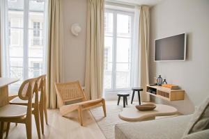 een woonkamer met een bank en een tv bij Luxury and Design Perfect Apt Mouffetard 5th in Parijs