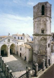 un edificio antiguo con una torre y un patio en Casa MaLù 18, en Monte SantʼAngelo