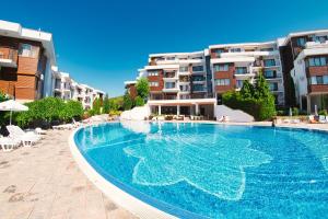 a large swimming pool in front of some buildings at Messambria Fort Noks Beach Apartments in Elenite