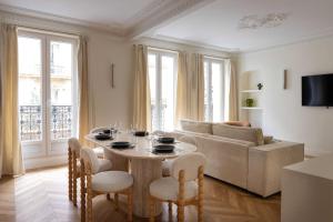 een woonkamer met een tafel en een bank bij Sumptuous flat for 6 people Etoile in Parijs