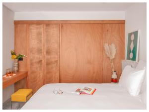 sypialnia z białym łóżkiem z drewnianym zagłówkiem w obiekcie Vertime Les Sables w mieście Les Sables-dʼOlonne