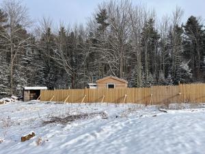 einen Zaun in einem schneebedeckten Hof in der Unterkunft EcoCottage Private Hot Tub in Union