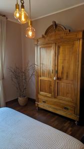 a large wooden cabinet in a room with a bed at Casa Reggiana in Reggio Emilia
