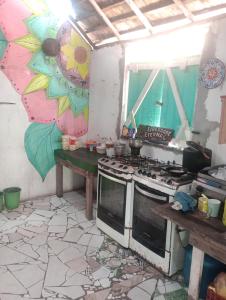 a kitchen with a stove and a sink and a counter at Cabana família coruja in Camaçari