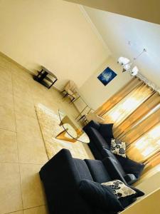 uma sala de estar com um sofá azul e uma janela em Luxurious & Fully Spacious 2 BR Apt' em Dubai