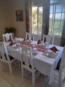 mesa de comedor blanca con sillas blancas y mantel blanco en Retreat Guest House, en Falmouth