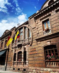 um edifício com duas bandeiras à frente em Hotel Victoria em Cuenca