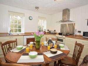 a kitchen with a table with a vase of flowers on it at 5 Bed in Glasson 36969 