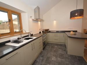 a kitchen with white cabinets and a sink and a window at 2 Bed in Bideford 32240 in Parkham