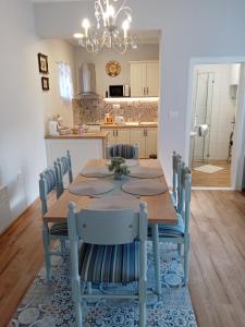 a dining room table with chairs and a kitchen at Apartman Katarina Bački Monoštor in Bački Monoštor