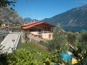 a house on the side of a lake with mountains at Hotel Florida in Limone sul Garda
