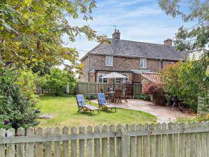 a house with a fence and chairs in the yard at 2 Bed in Stowmarket 37011 in Stowmarket